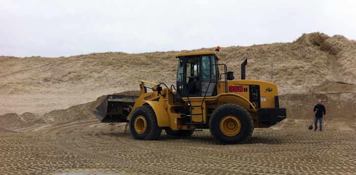 De grote gele shovel van Schoorl legt een zandbaan aan bij de duinen